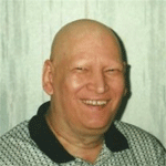 A man with a bald head smiling for the camera.