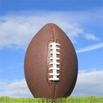 A football is sitting on top of a grassy field.